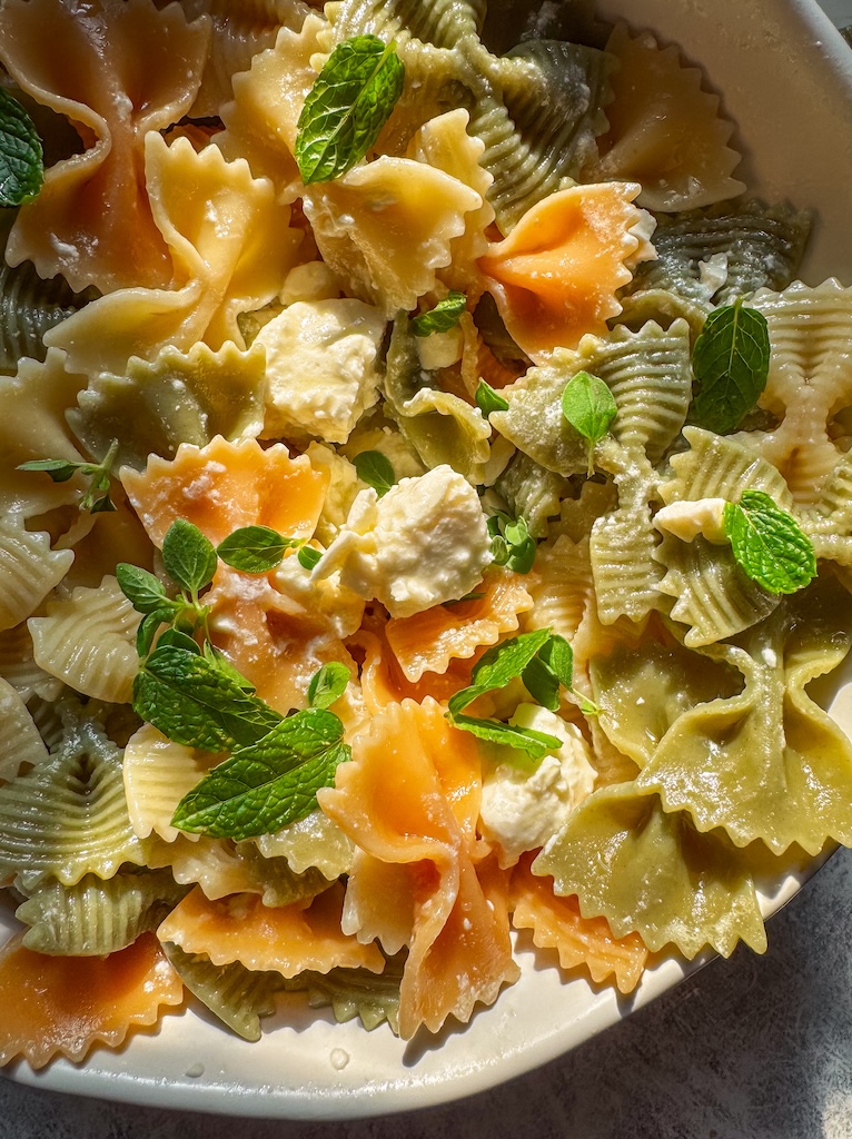Fresh Greek-inspired pasta salad made with bow tie pasta, cucumbers, tomatoes, feta, olives, and homemade lemon dressing.