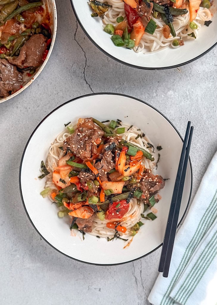 Beef and kimchi yakisoba noodles with vegetables and sesame seeds in a bowl — a quick and flavorful Asian stir-fry recipe.