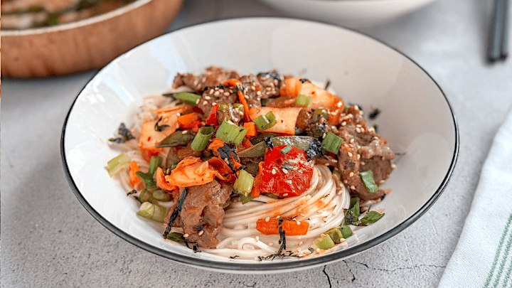 Beef and kimchi yakisoba noodles with vegetables and sesame seeds in a bowl — a quick and flavorful Asian stir-fry recipe.