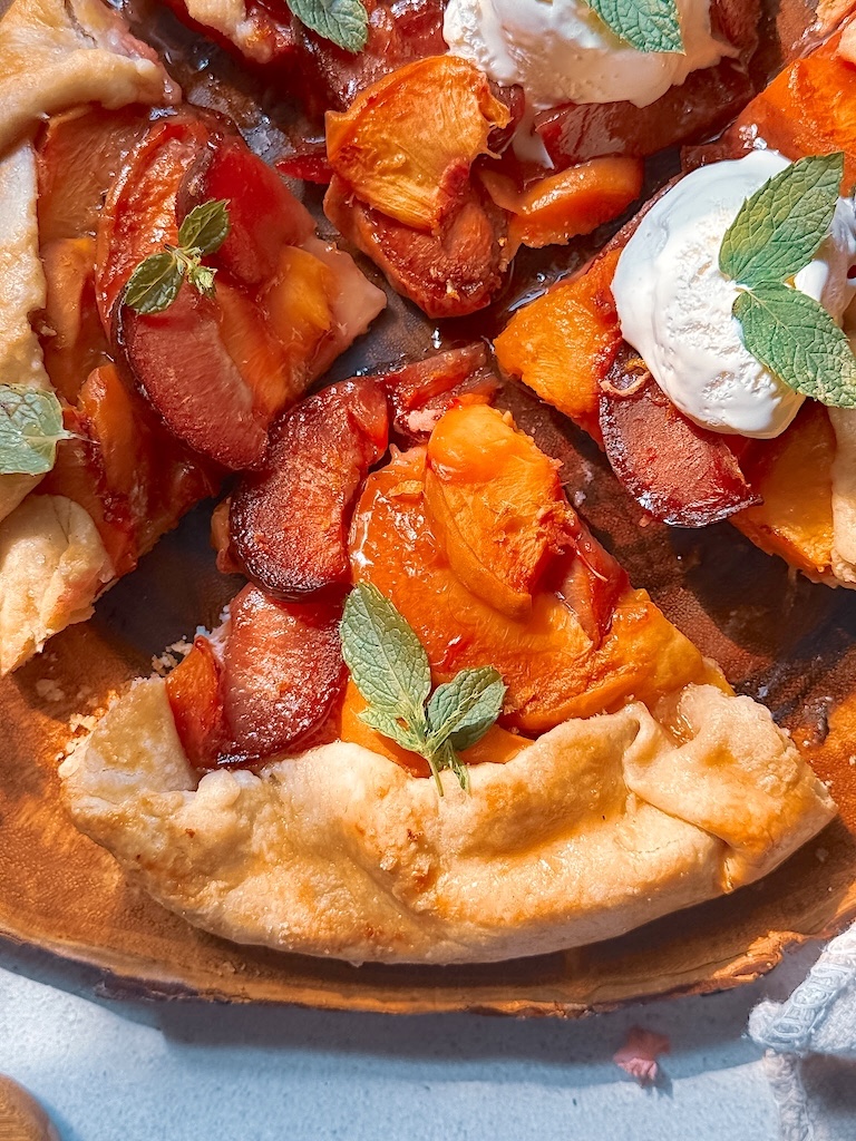 This easy Plum and Peach Galette is the perfect summer dessert! Made with sweet peaches, juicy plums, and a buttery homemade crust, this rustic fruit galette is simple to make and absolutely delicious served warm with vanilla ice cream.