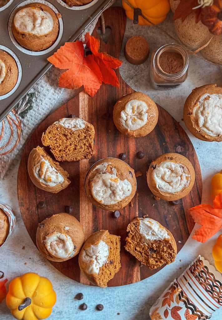 Pumpkin cream cheese muffins with chocolate chips on wooden board – fall baking recipe inspired by Starbucks pumpkin muffin.