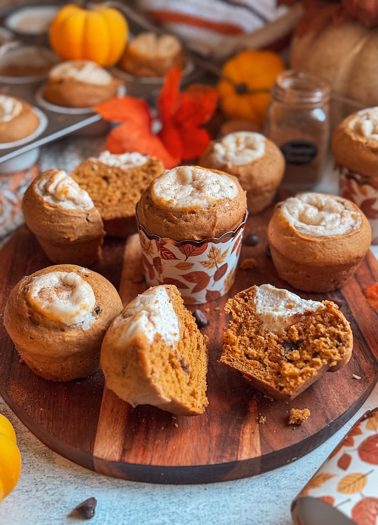 Pumpkin cream cheese muffins with chocolate chips on wooden board – fall baking recipe inspired by Starbucks pumpkin muffin.