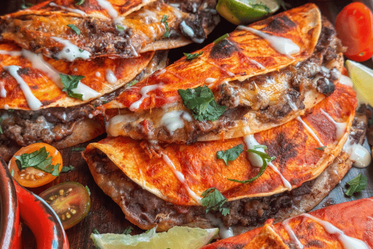 Baked beef and bean soft tacos with melted cheese and taco sauce