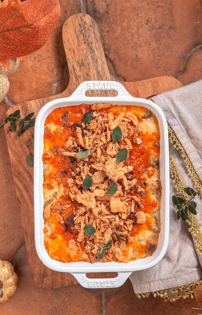 Cheesy green bean casserole in a 2-quart dish topped with crispy fried onions