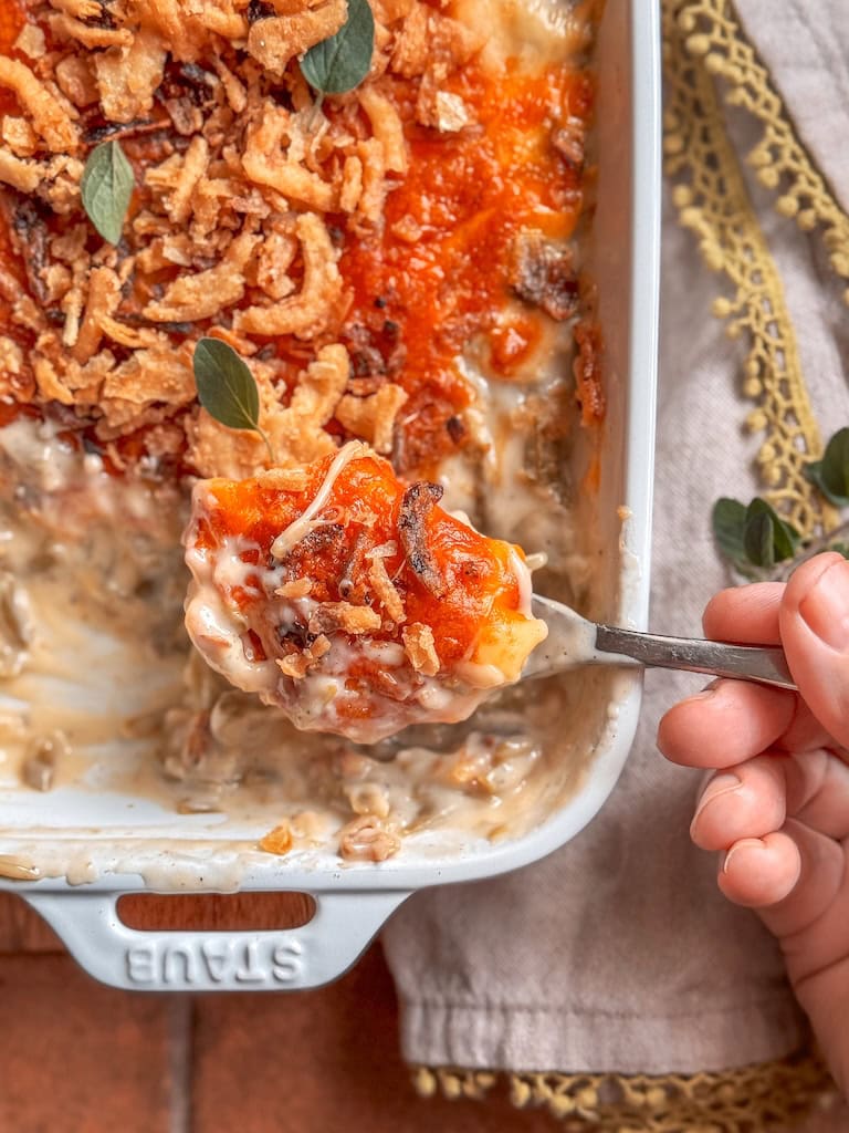 Close-up of creamy green bean casserole with melted cheese and golden onions