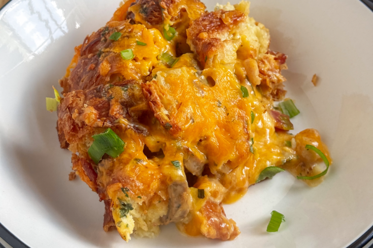 Croissant breakfast casserole with chicken sausage, bacon, cheddar cheese, and scallions