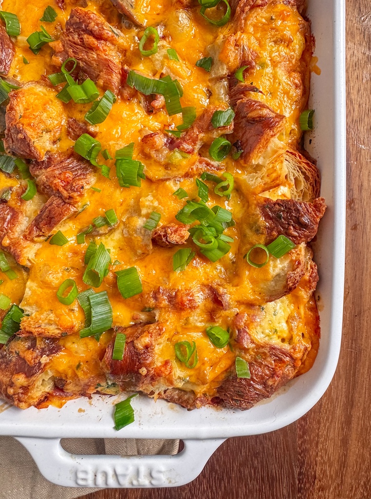 Croissant breakfast casserole with chicken sausage, bacon, cheddar cheese, and scallions