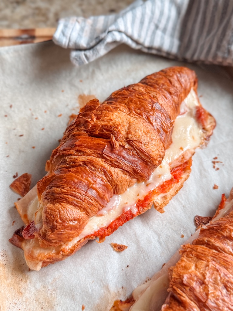 Baked pizza croissant sandwich filled with mozzarella cheese, smoked turkey, mini pepperoni, and marinara sauce.